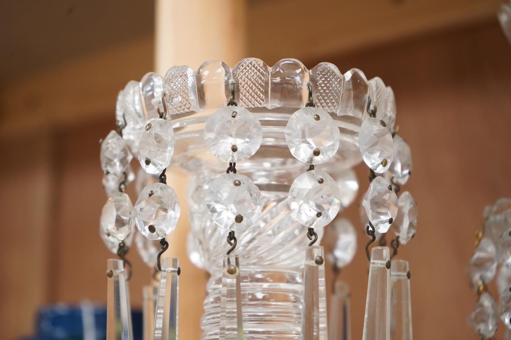 A pair of Victorian cut glass lustre candlesticks and one larger candlestick, 24cm high